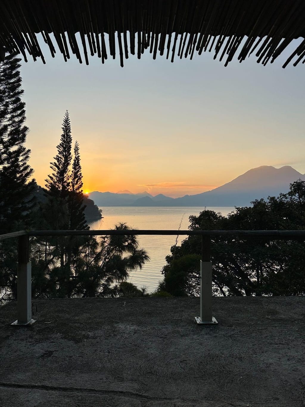 A sunset over Lake Atitlán and its volcanoes, seen from a balcony in San Marcos La Laguna
