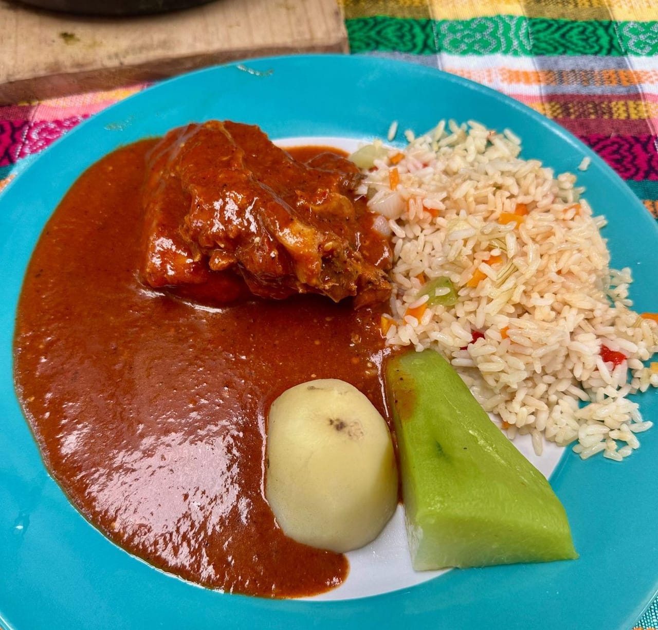 A plate of Dina's pepián with fresh tortillas used to scoop up the sauce