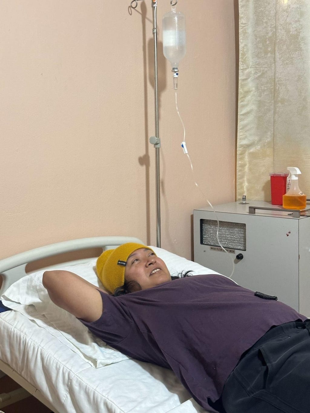 Jackie sitting in a hospital gown after receiving treatment, looking relieved